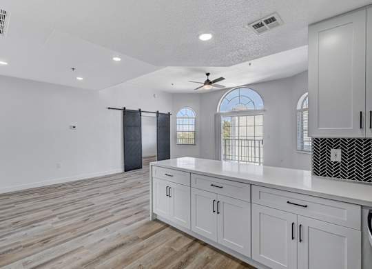 A kitchen with wooden floors and white cabinets.