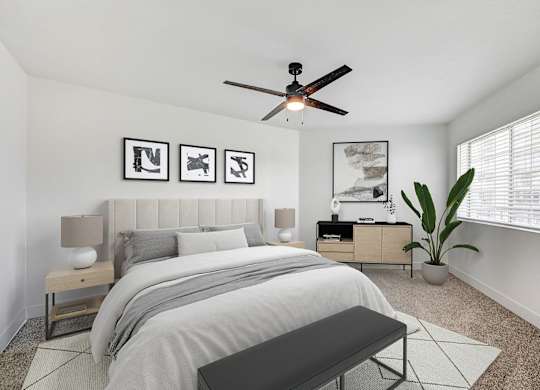 A bedroom with a bed, nightstands, and a ceiling fan.