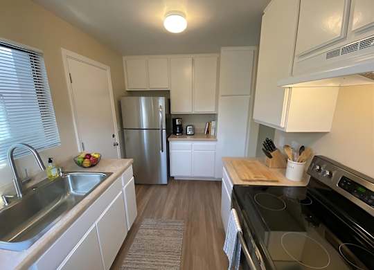 A kitchen with white cabinets and a black stove top oven.