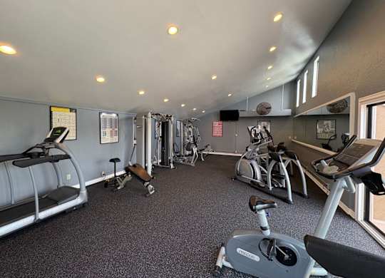 A gym with treadmills, elliptical machines, and other exercise equipment.