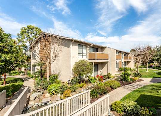 A residential building with a well-maintained garden in front.