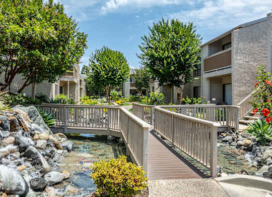 A bridge over a stream in a residential area.