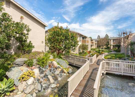 A bridge over a stream in a residential area.