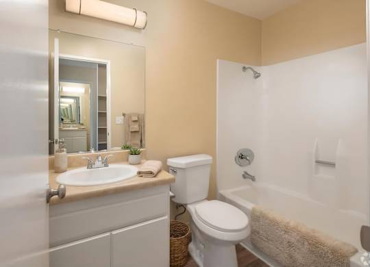A bathroom with a white toilet, sink, and bathtub.