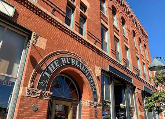 Exterior brick facade of The Burlington apartments showing  main entry door.