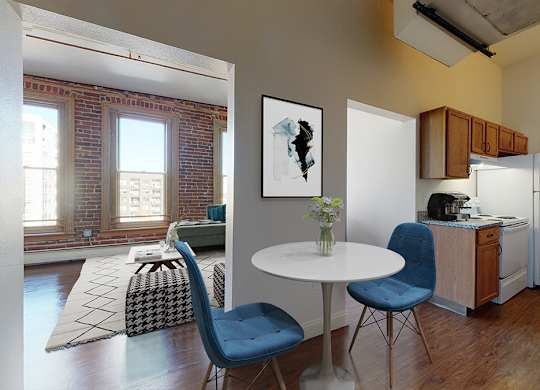 A galley kitchen next to a small dining table and chairs