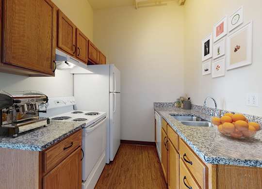 A kitchen with a white fridge and wooden cabinets.