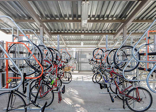 A bike rack full of bicycles in a parking area.