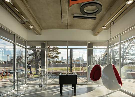 A room with a piano and two egg-shaped chairs.