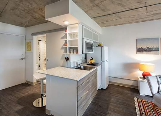 A modern kitchen with a white island and a refrigerator.