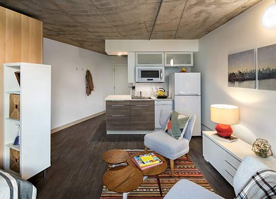 A modern kitchen with a refrigerator, microwave, and oven.