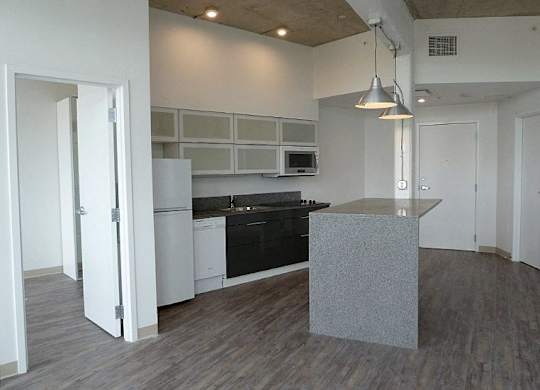 A kitchen with a black countertop and white cabinets.