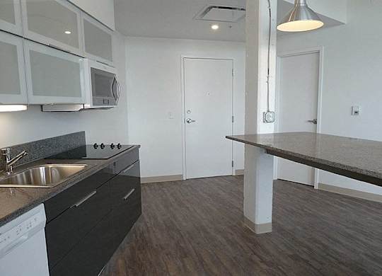 A kitchen with a sink, stove, and microwave.