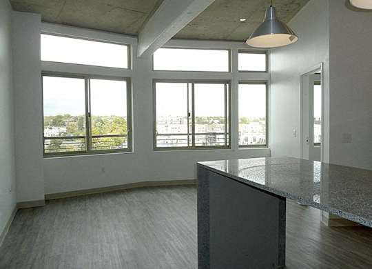 A large empty room with a concrete floor and a long counter.