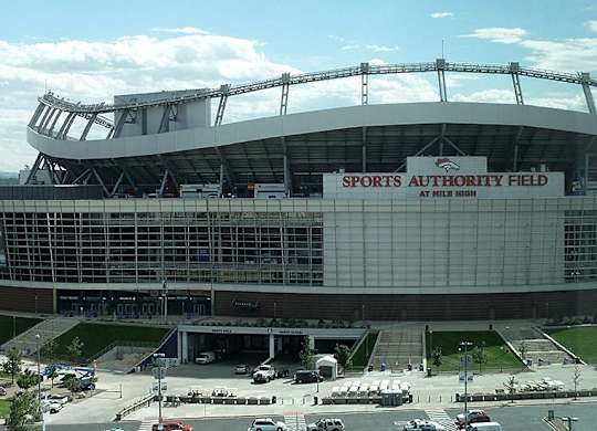 A large stadium with a glass facade and a sign that reads