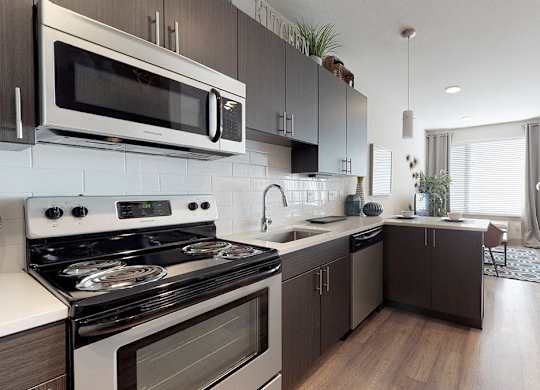 A modern kitchen with a stove, microwave, and oven.