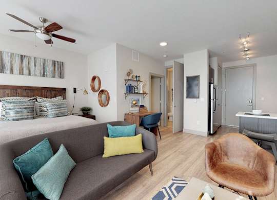 A living room with a grey couch and a brown chair.