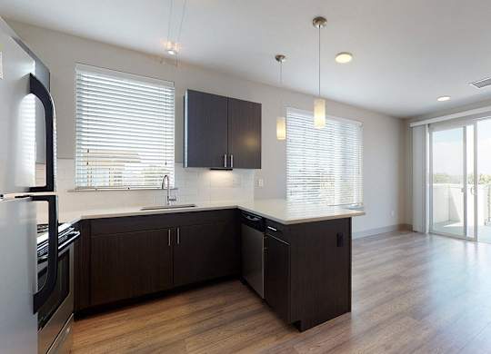 A modern kitchen with dark brown cabinets and a white refrigerator.