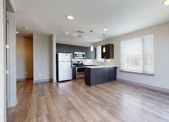 A kitchen with a refrigerator, microwave, and oven.