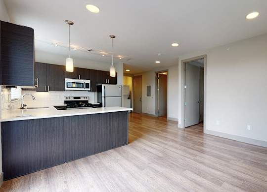 A modern kitchen with dark wood cabinets and a white countertop.