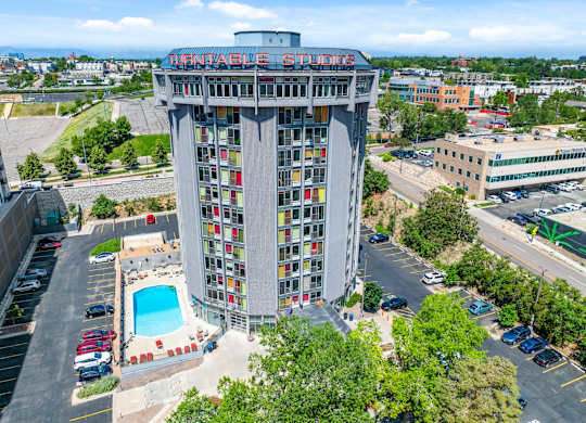 A tall building with a pool in front of it.