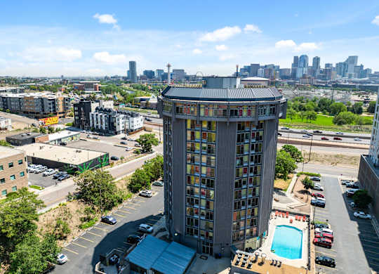 A tall building with a pool in the middle of a parking lot.