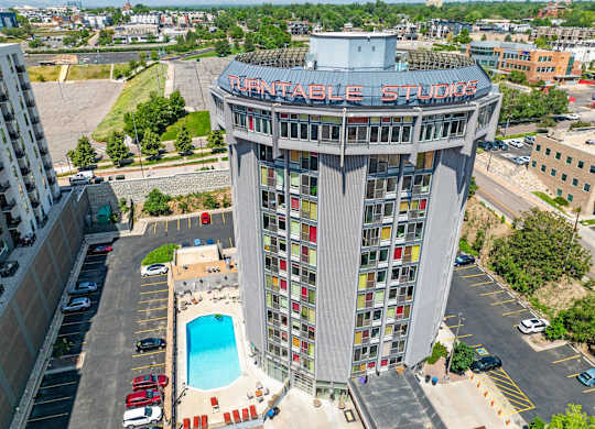 A tall building with a pool in front of it.