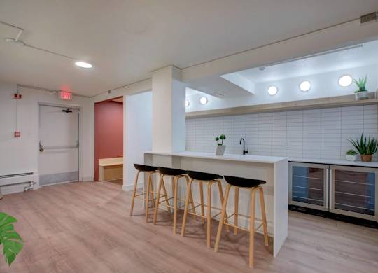 A community kitchen area with a bar and stools.