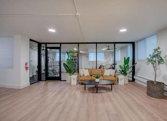 A modern living room with a wooden floor and a glass door leading to a balcony.
