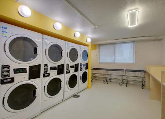 A row of stacked washers and dryers in a laundry room..