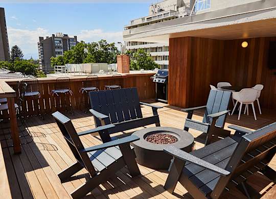 A wooden deck with chairs and a fire pit.