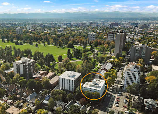 An aerial view of a city with a large building circled in orange.