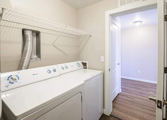 A white washer and dryer in a small laundry room.