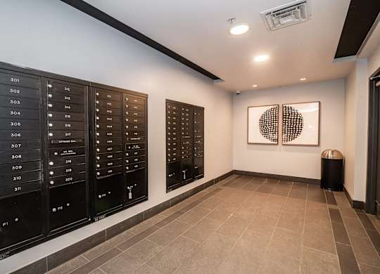 A hallway with a row of mailboxes on the wall.