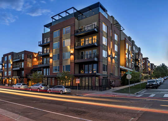 A modern apartment building with cars parked in front.