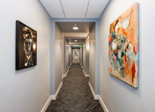 A hallway with two paintings on the wall.