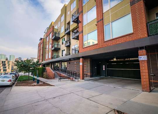 A multi-story building with a parking lot in front.