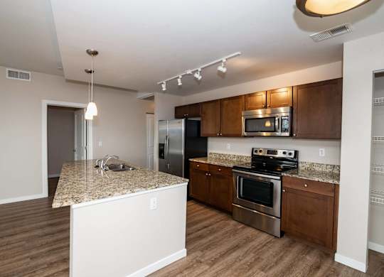 A kitchen with wooden cabinets and a granite countertop.