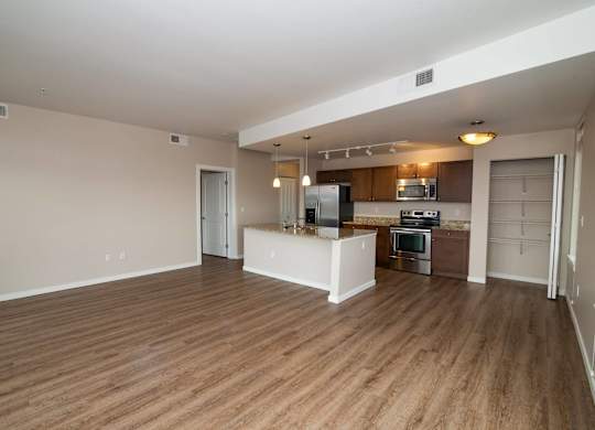 A spacious living area with a kitchen in the background.