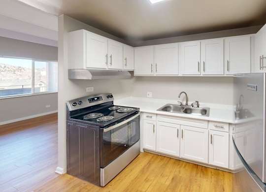 A kitchen with white cabinets and a stainless steel refrigerator.