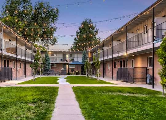 A courtyard surrounded by apartment buildings with a walkway in the middle.