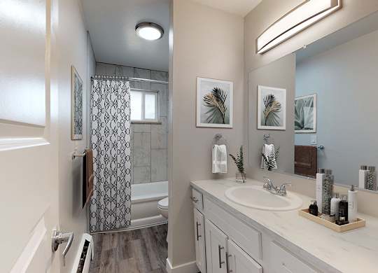A bathroom with a white sink and a shower with a glass door.