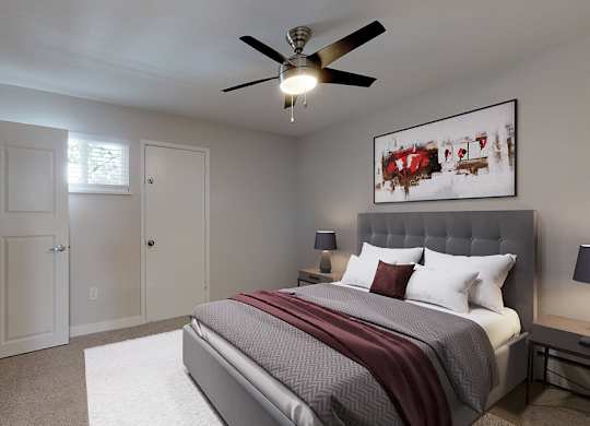 A bedroom with a large bed and a ceiling fan.