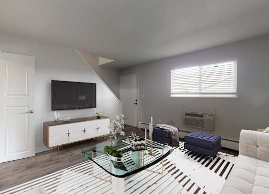 A modern living room with a glass coffee table and a television.