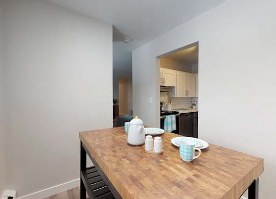 A kitchen with a table in the foreground.