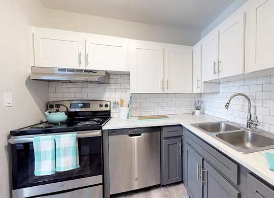 A kitchen with a stove, oven, and sink.