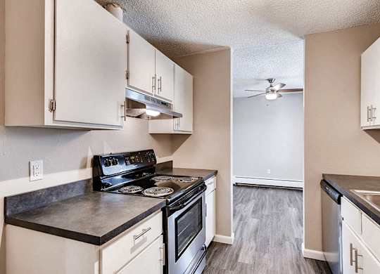 A kitchen with black countertops and white cabinets.