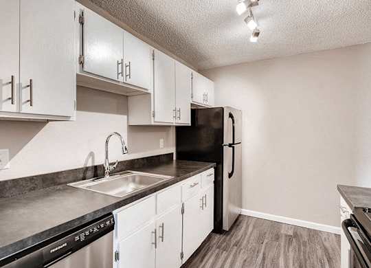 A kitchen with black appliances and white cabinets.
