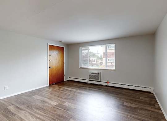 Empty room with wooden floors and white walls.