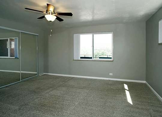 A room with a ceiling fan and a window.